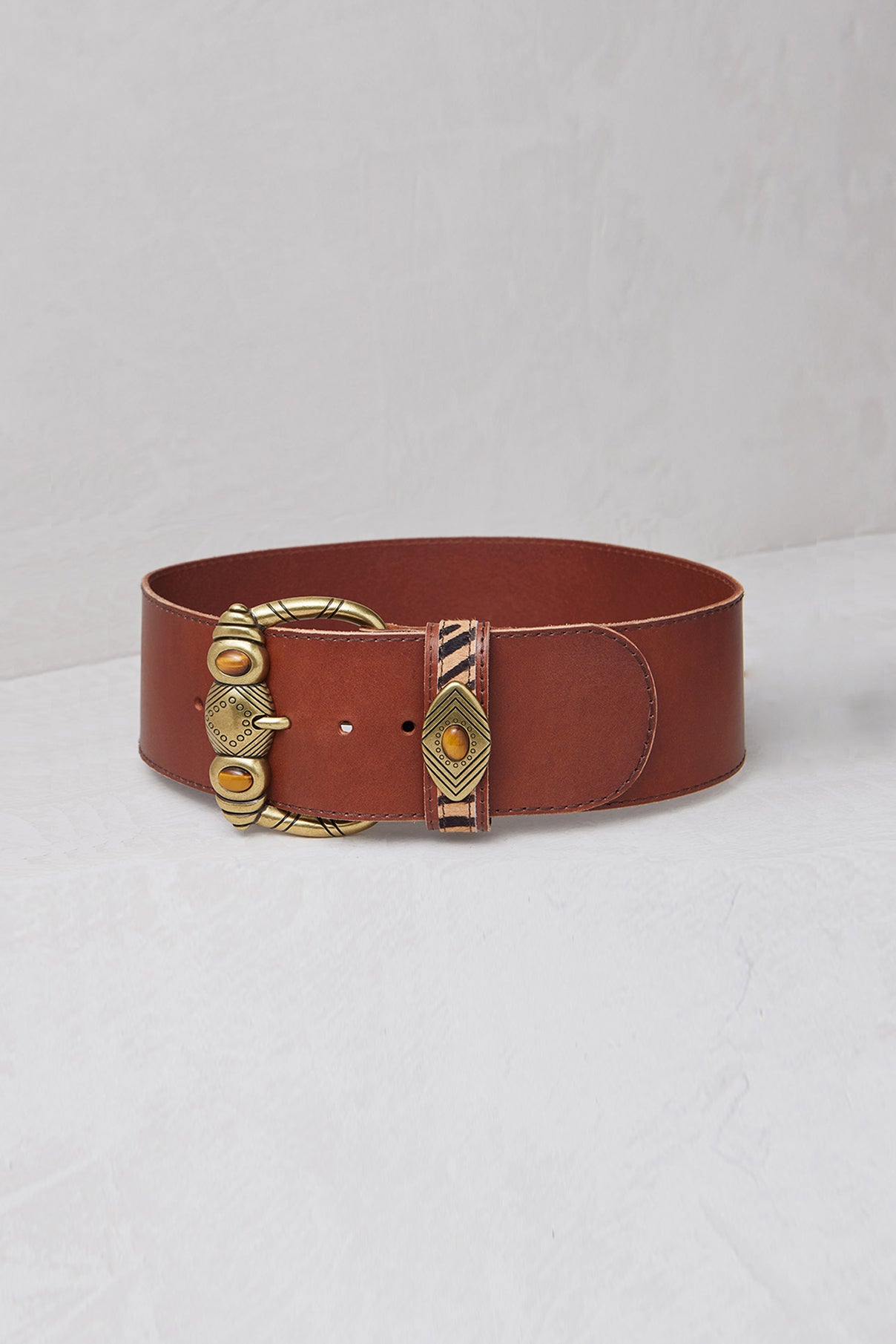 Close-up of Aspen black belt showing zebra inlay and polished tiger’s eye buckle.