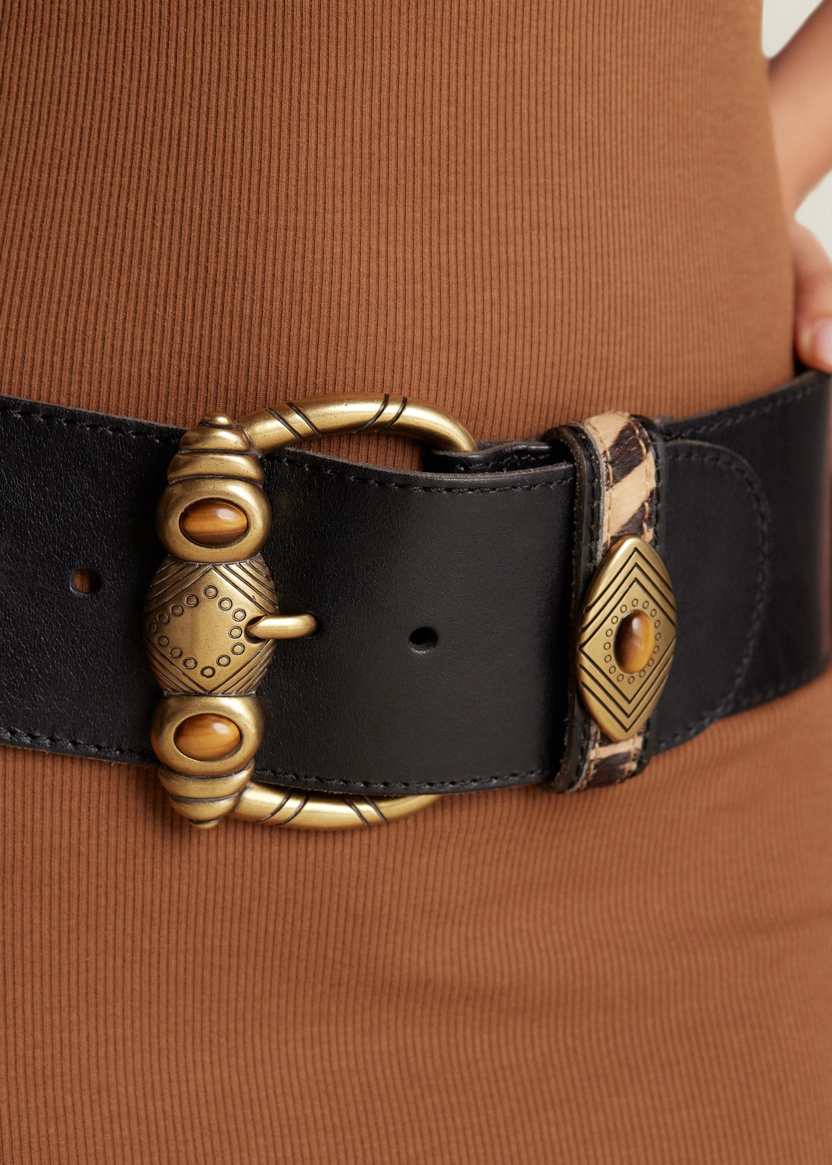 The Aspen Belt: Featuring semi-precious stones on an embossed buckle, it's an archival vintage design with a contour shape. With a width of 3”, zebra haircalf, and hand-burnished vintage leather, it captivates with timeless quality. 