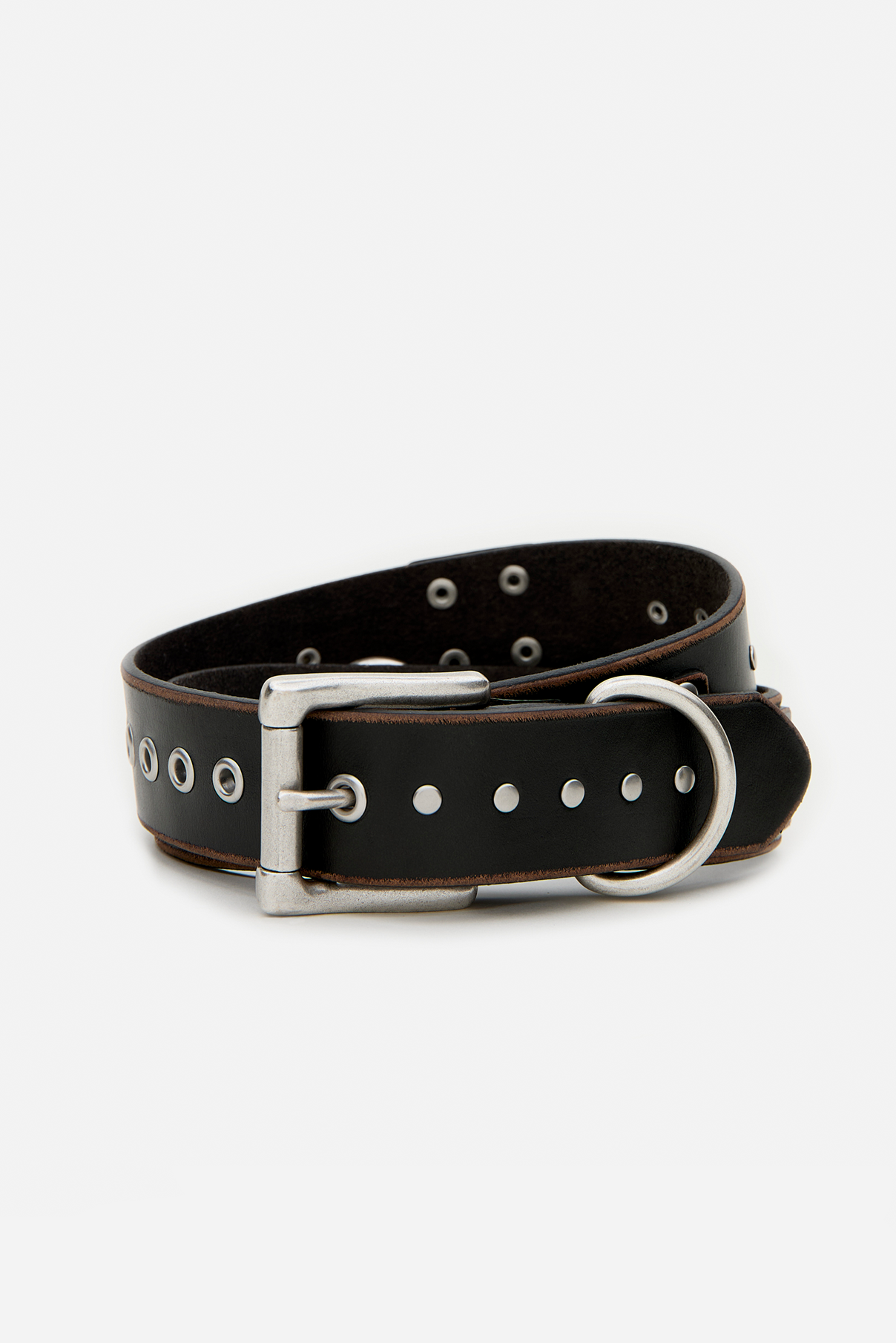 Coiled Frankie black vintage belt highlighting silver grommets and rectangular buckle.