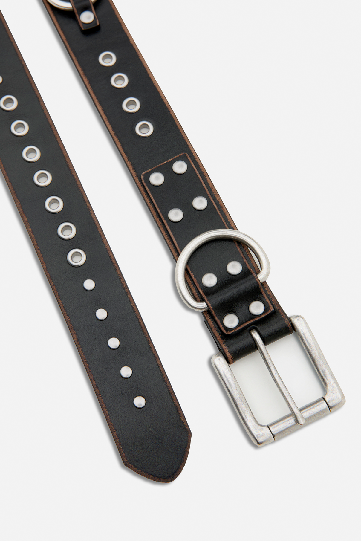 Close up flat lay of the Frankie black vintage belt highlighting silver grommets and rectangular buckle.