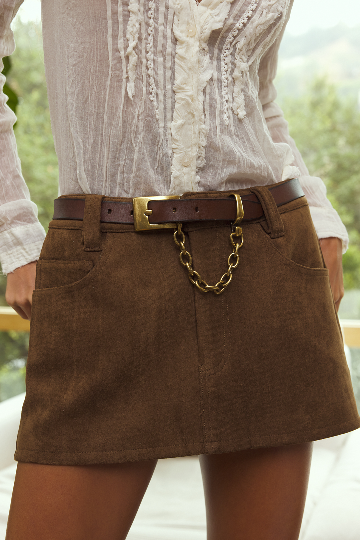 Close-up view of the Ledger brown belt on model, showcasing chain and buckle details.