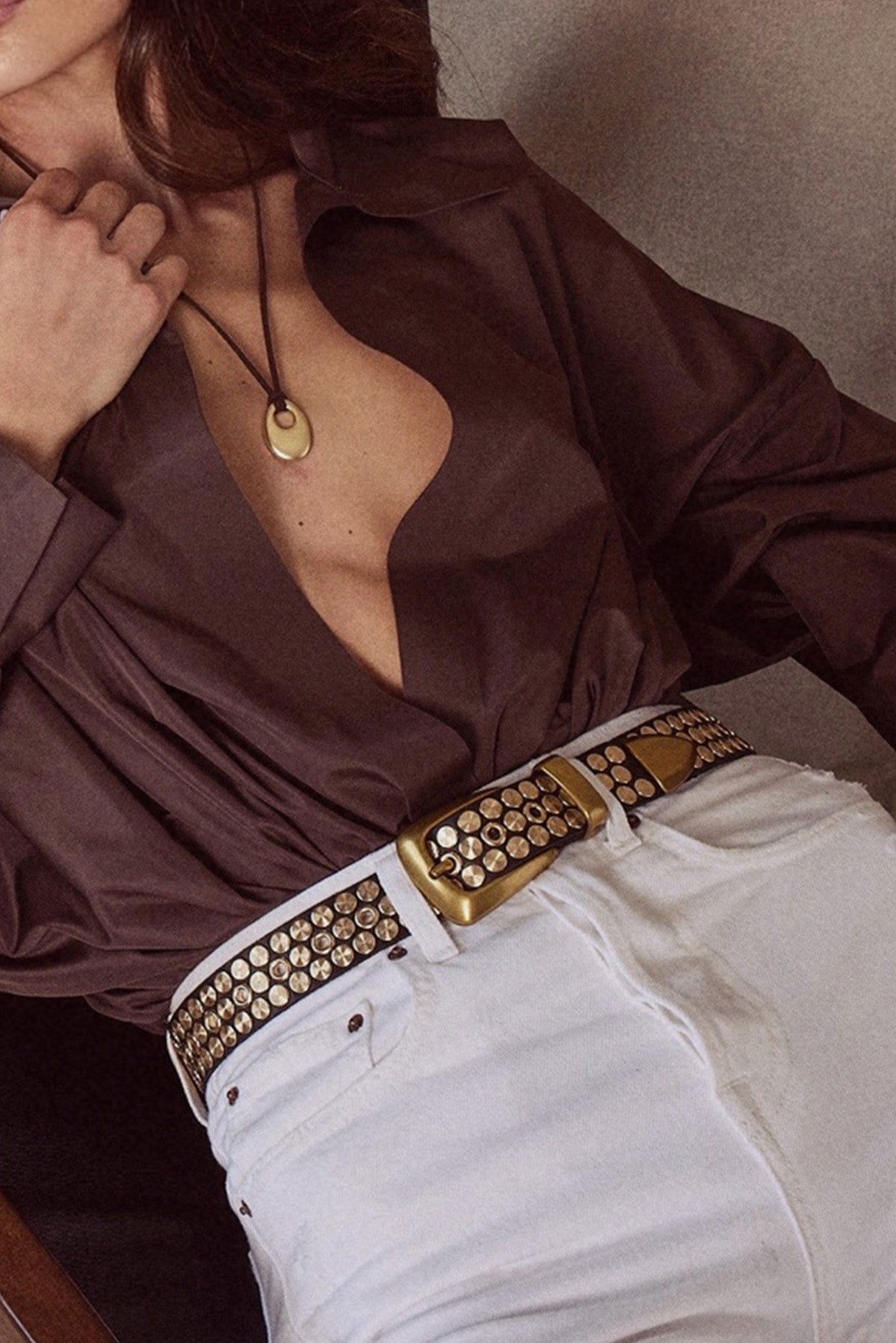 Close-up of the Colton black leather belt showing stud pattern and gold buckle.